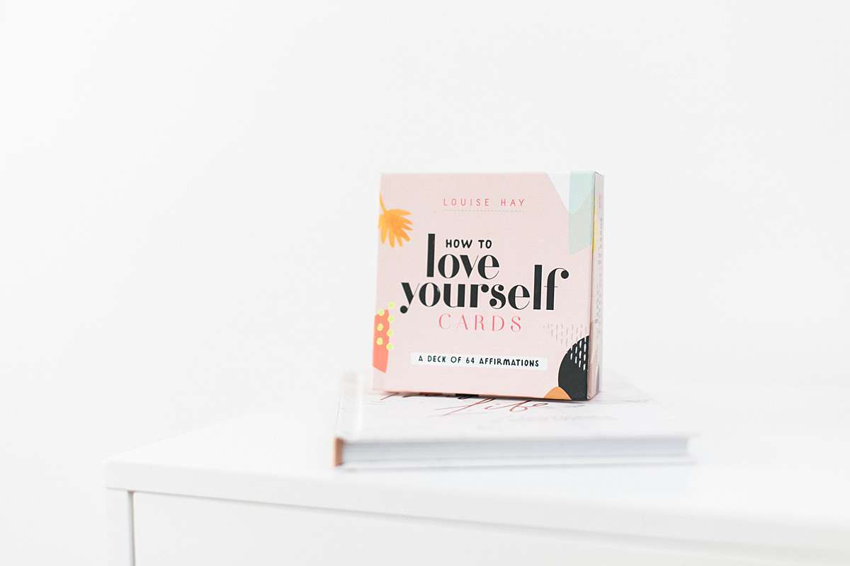 stack of personal growth affirmation books feminine