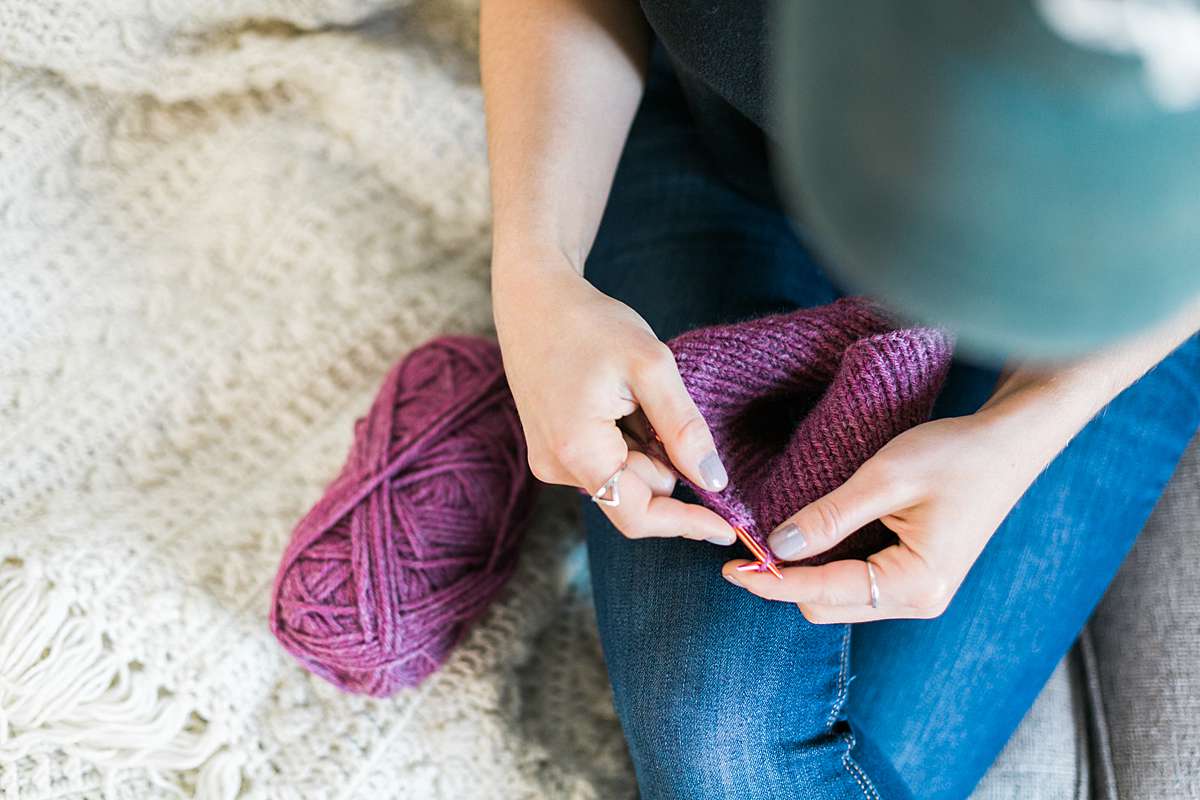 woman knitting with purple yarn