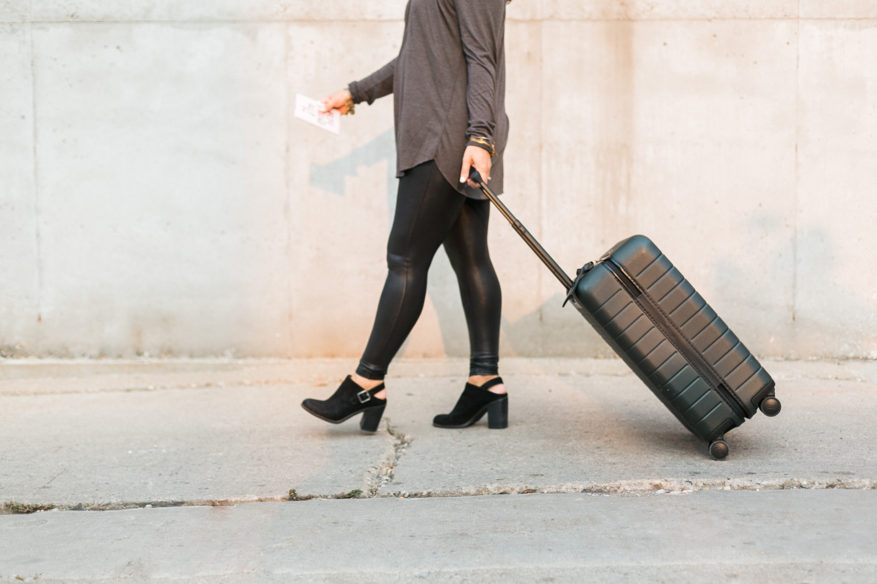 woman pulling an away luggage suitcase