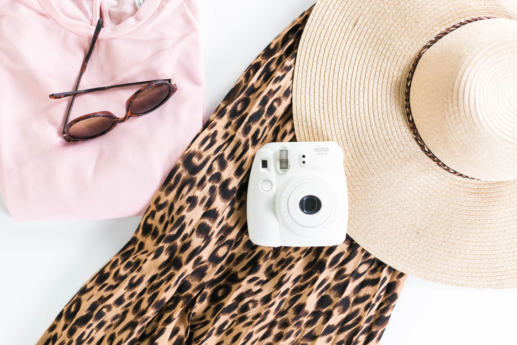 leopard print outfit flatlay with camera and hat