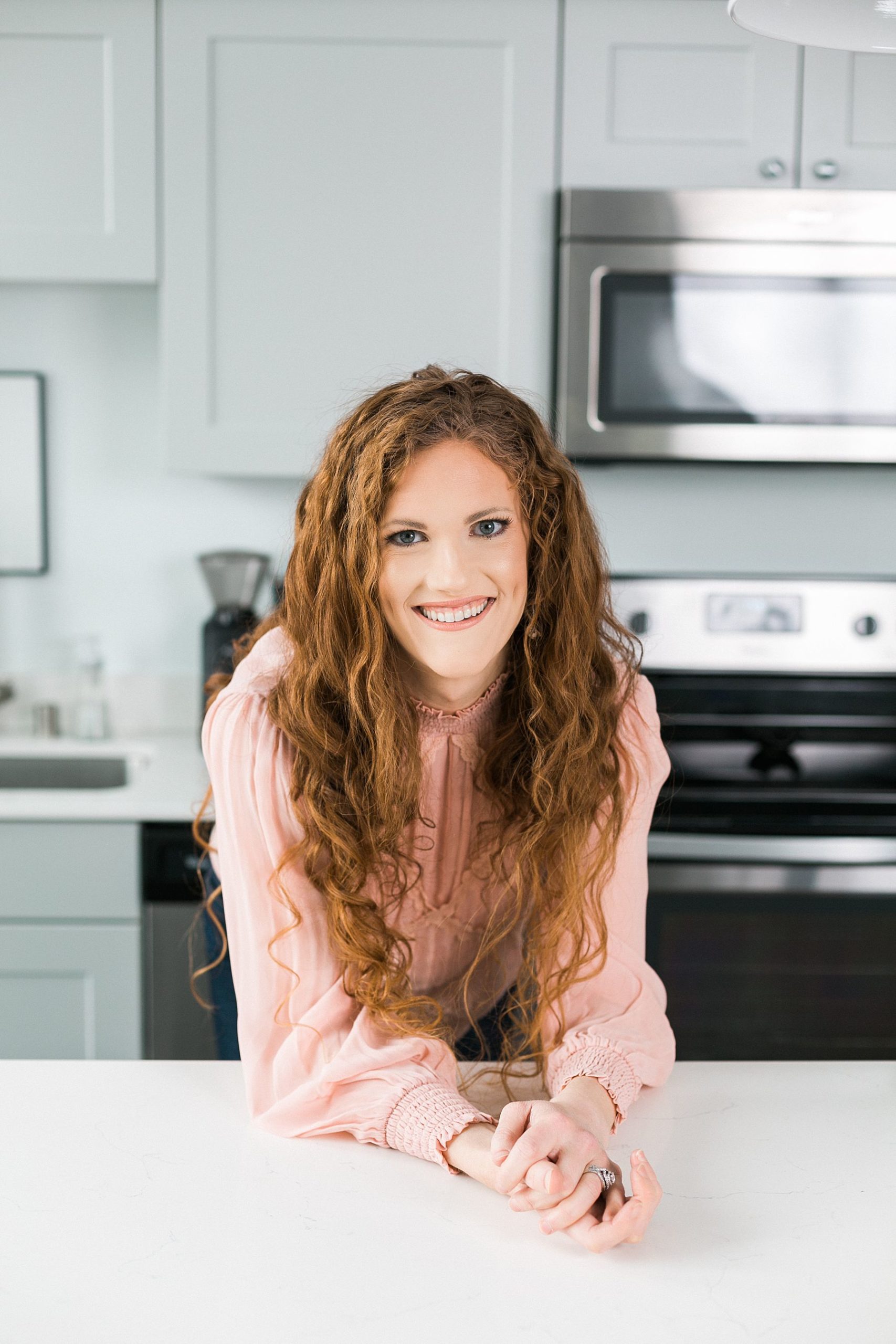 leaning over kitchen counter headshot for wellness coach