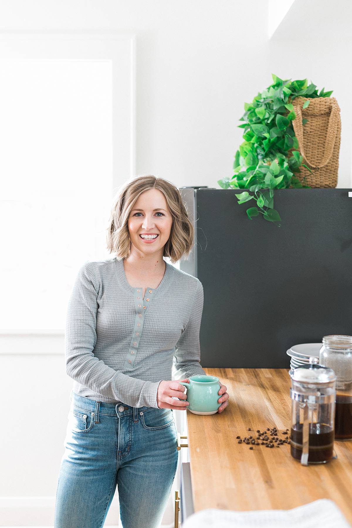 wellness blogger making cold brew iced coffee in modern white kitchen