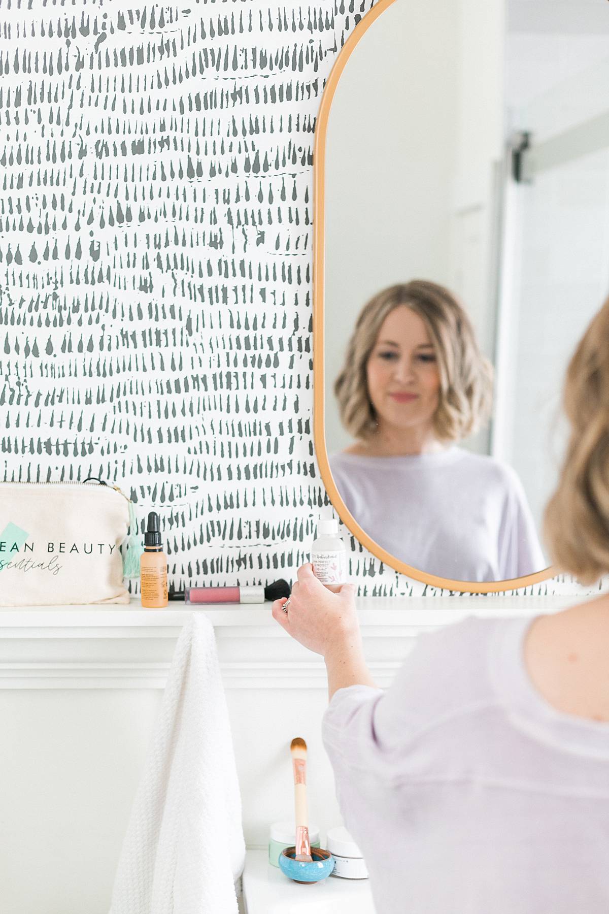 natural and organic beauty blogger in bathroom mirror