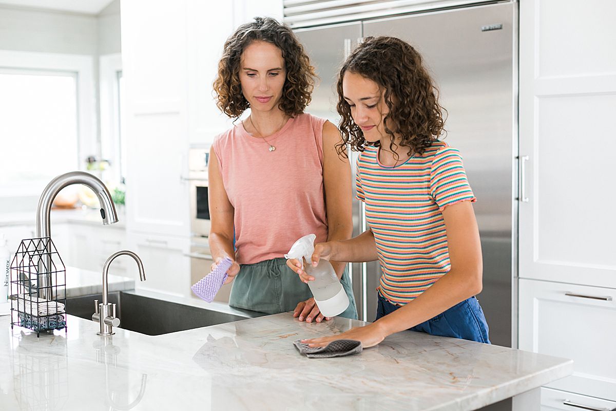woman and daughter cleaning in kitchen