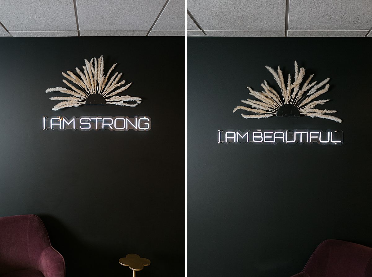 neon wall signs at blow dry bar that read "i am strong" and "i am beautiful"