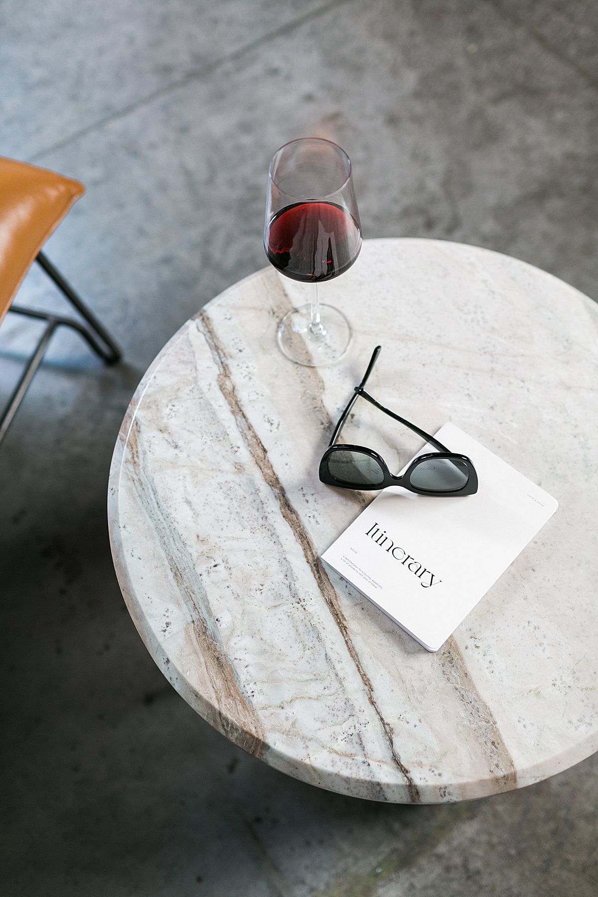 itinerary sunglasses and wine on a marble table