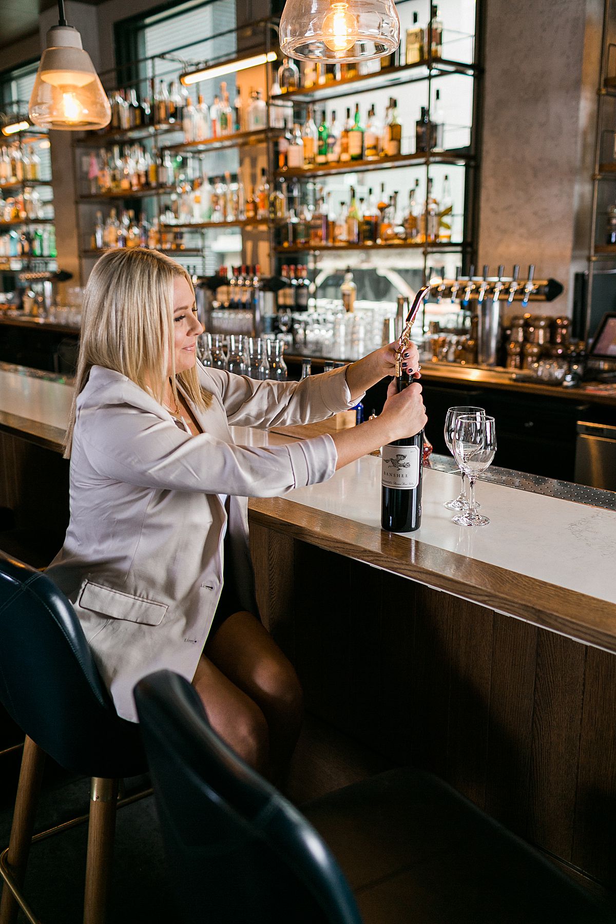 woman CEO in upscale hotel bar with glass of wine in hand