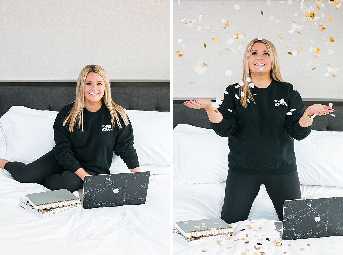 woman in upscale hotel room throwing confetti and working on laptop