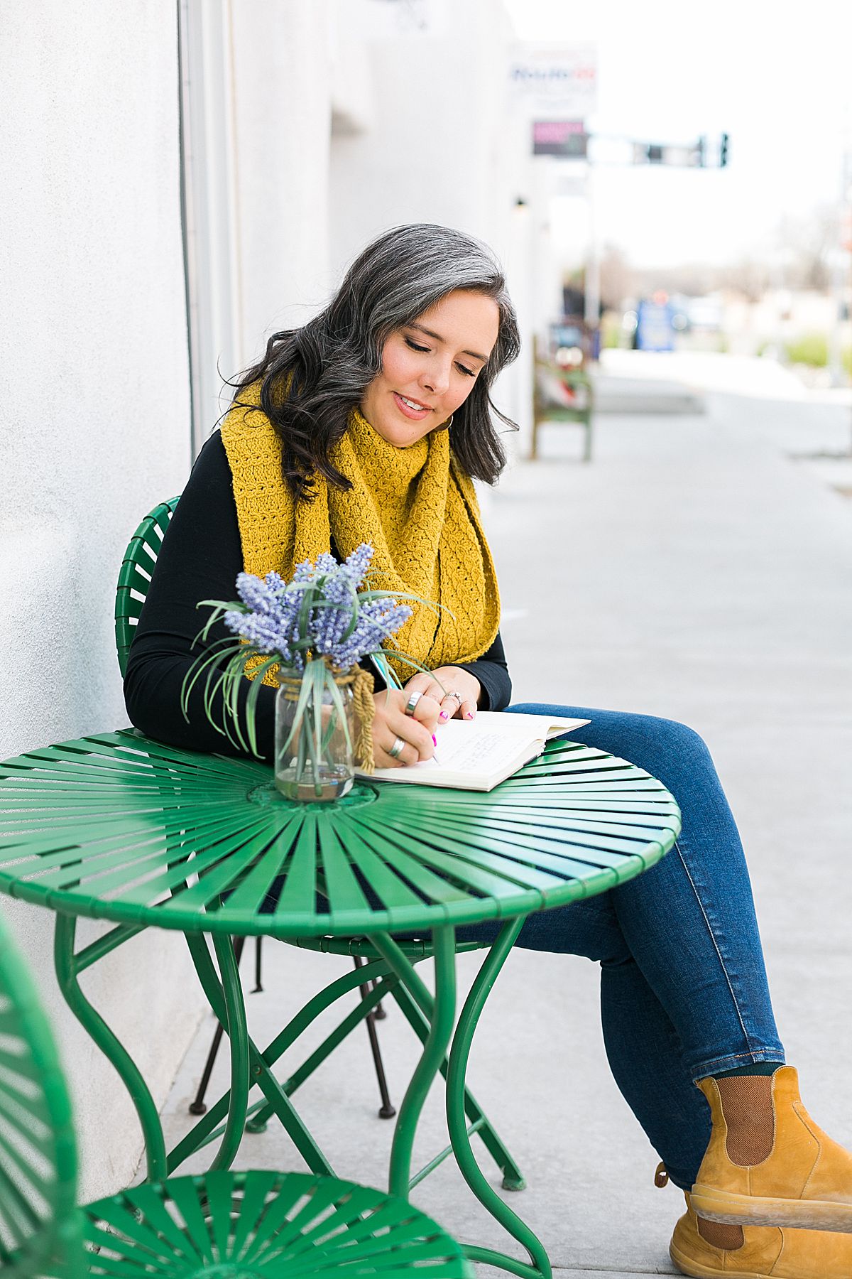 woman journaling outdoors on a green table