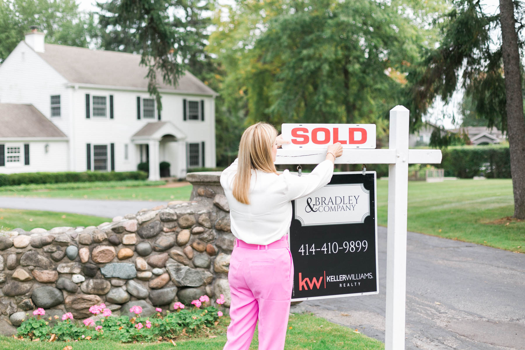 real estate agent by sold sign