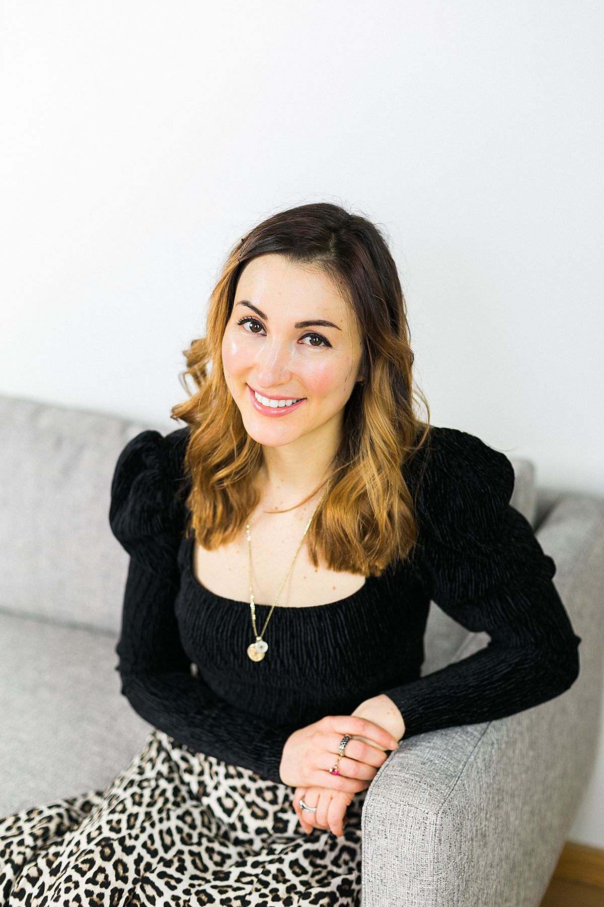 woman business coach headshot on gray couch