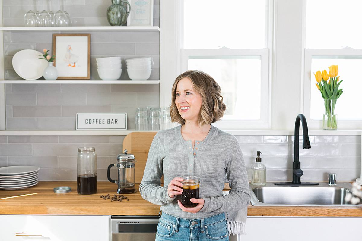 milwaukee wisconsin wellness blogger with cold brew coffee in modern white kitchen