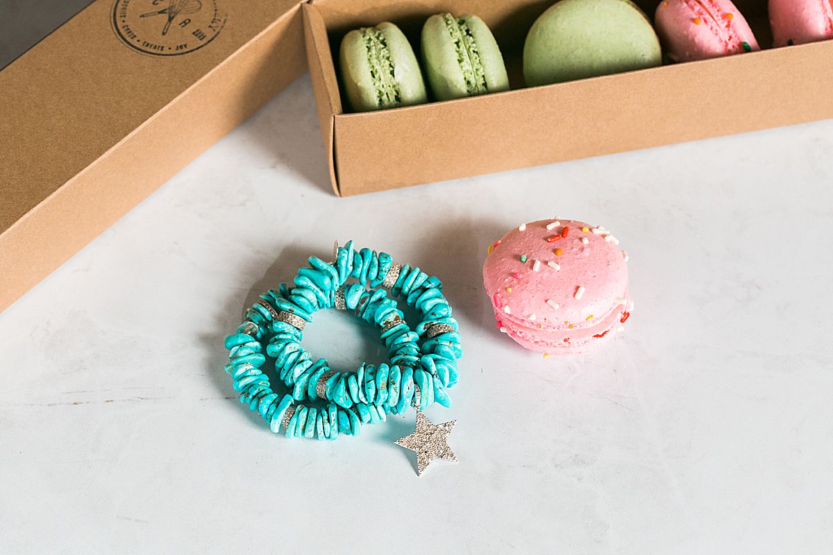 turquoise bracelets next to macaron cookies