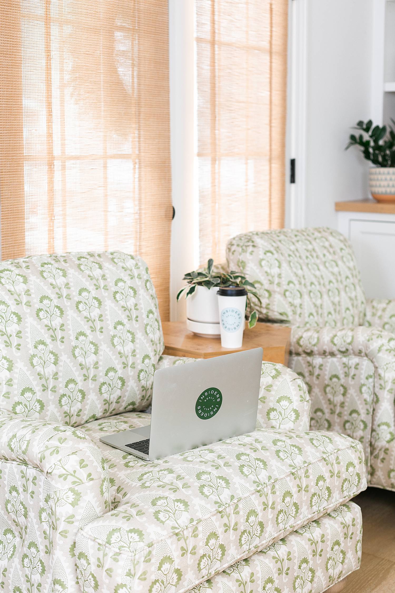 laptop open in living room on green patterned chair