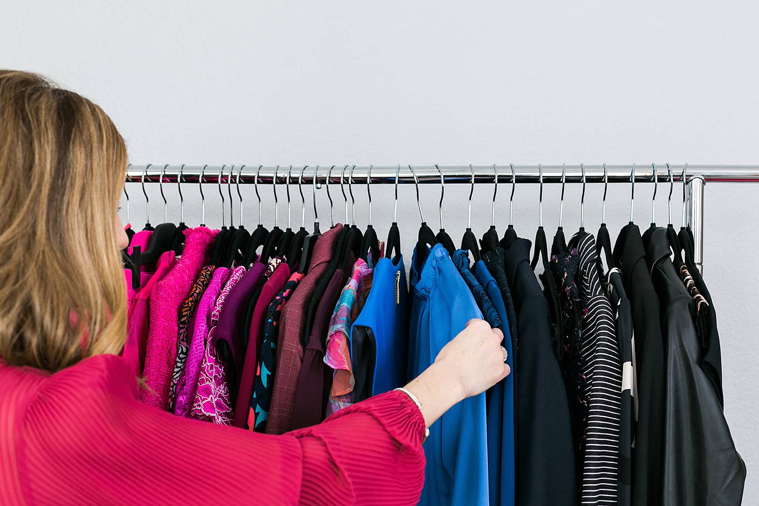 image consultant choosing an outfit from rolling wardrobe rack