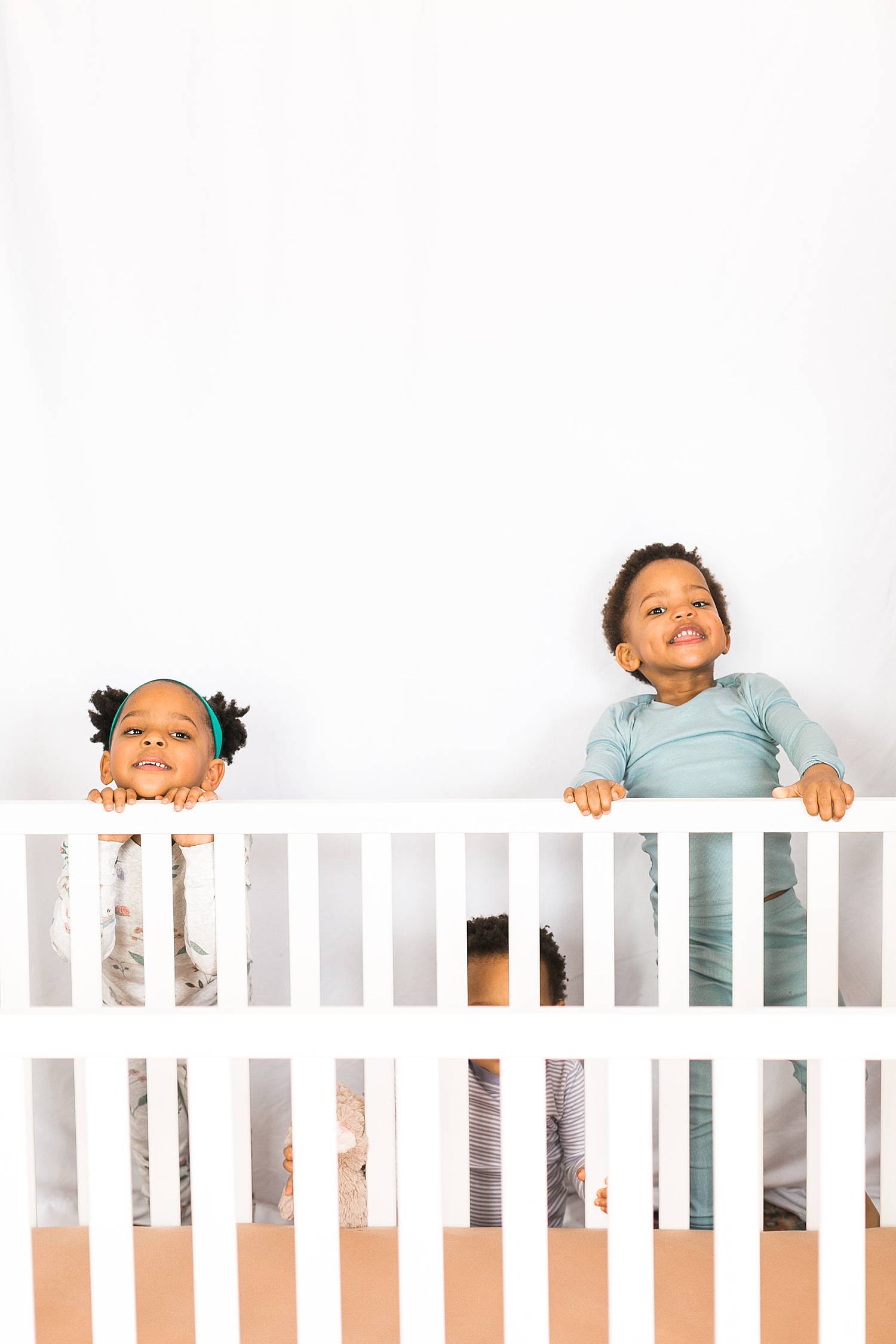 toddlers at the edge of crib before bedtime, content for sleep consultants