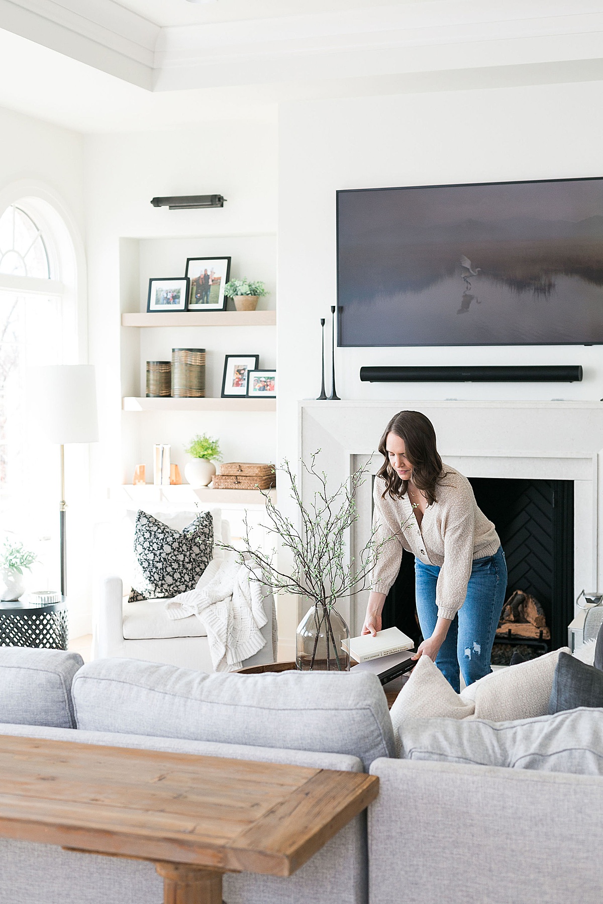 woman styling a modern aesthetic living room for spring